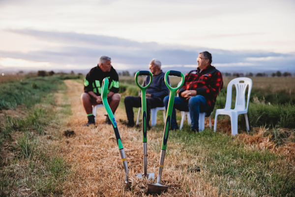 Cutwater Road wetland - three men sitting with spades in foreground